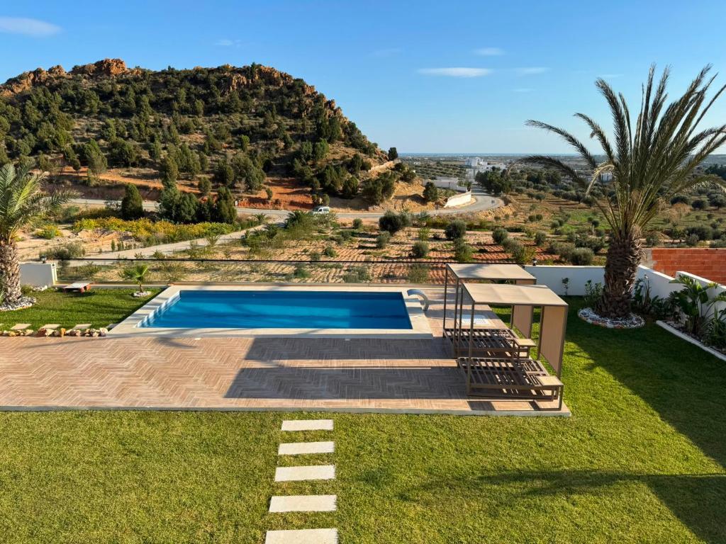 a villa with a swimming pool and a mountain at Prestige Pool Retreat in Hammamet