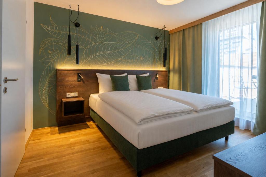 a bedroom with a large bed with a green wall at Der Stasta - New Opening in Vienna
