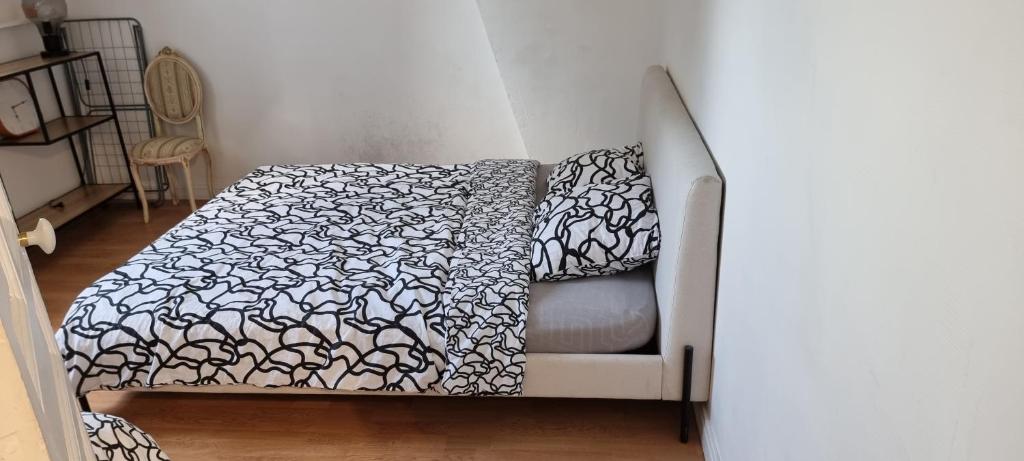 a couch with a blanket on it in a room at Appartement T2 Proche du CH d'Arras in Sainte-Catherine