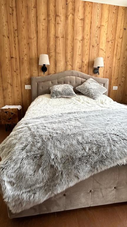 a bed with two pillows on it in a bedroom at Charming apartment pool, SPA, sauna, CIR VDA - AYAS - 0005- in Champoluc