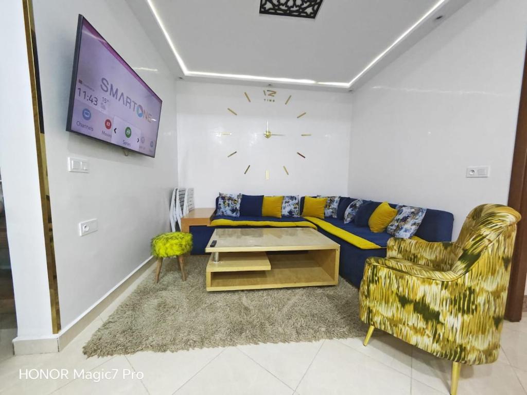a living room with a couch and a clock on the wall at Ouida App in Oujda