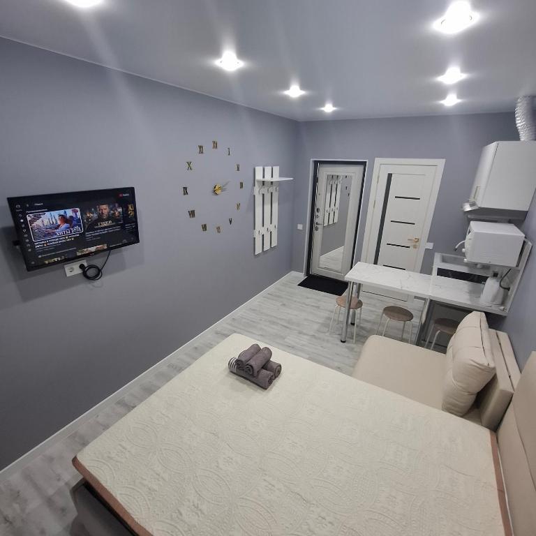 a living room with a couch and a tv on the wall at Byrabau Tauwer in Shchūchīnsk