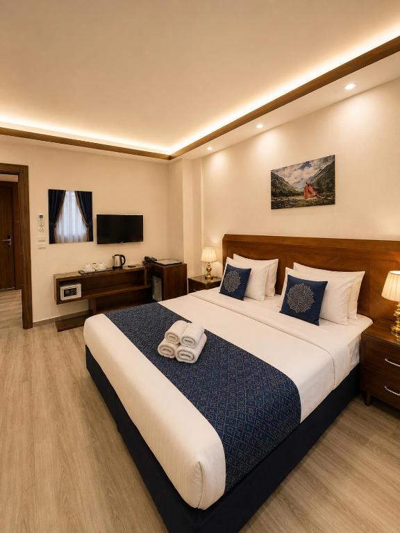 a hotel room with a large bed and a television at Sky Royal Hotel in Petra