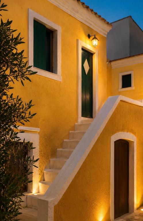 a yellow house with a green door and stairs at Pozzo House Corfu - Traditional House for 3 near Agios Georgios Beach in Argyrádes