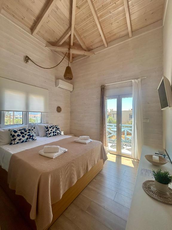 a bedroom with a large bed and a large window at Sea and Sand Elafonisos in Elafonisos