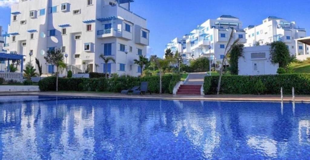 a large swimming pool in front of some buildings at Smirpark appartement in M'diq