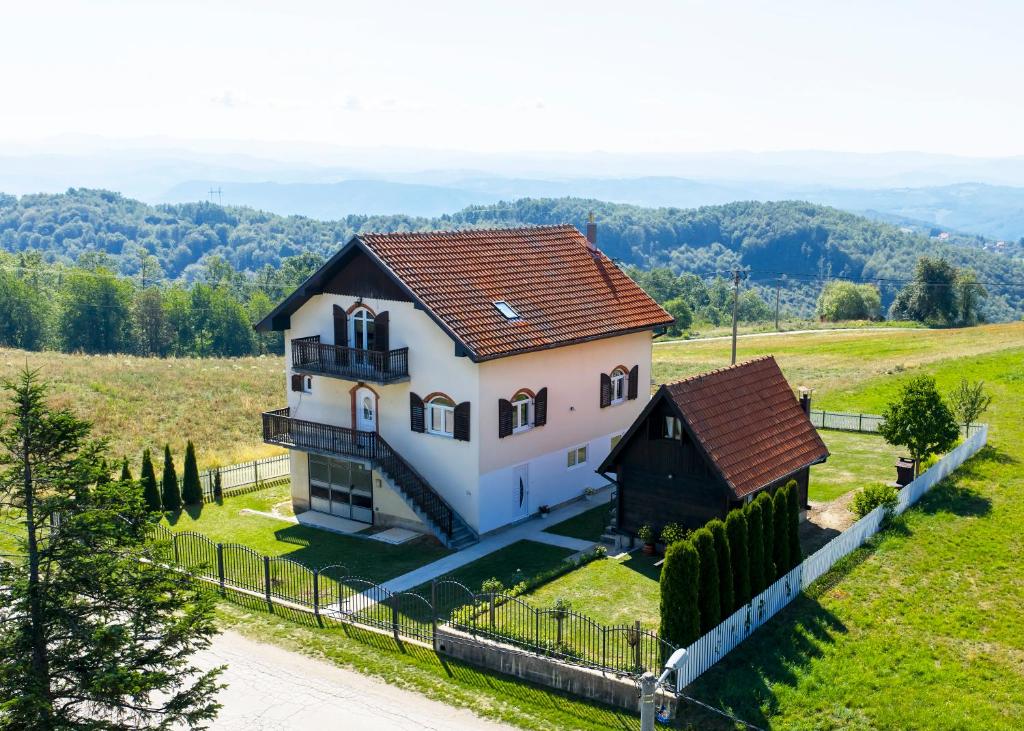 a small house in a field with a fence at Evergreen Escape Apartment in Užice