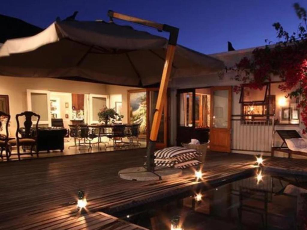 a patio with an umbrella on a deck at The Gregoire Boutique Villa in Hermanus