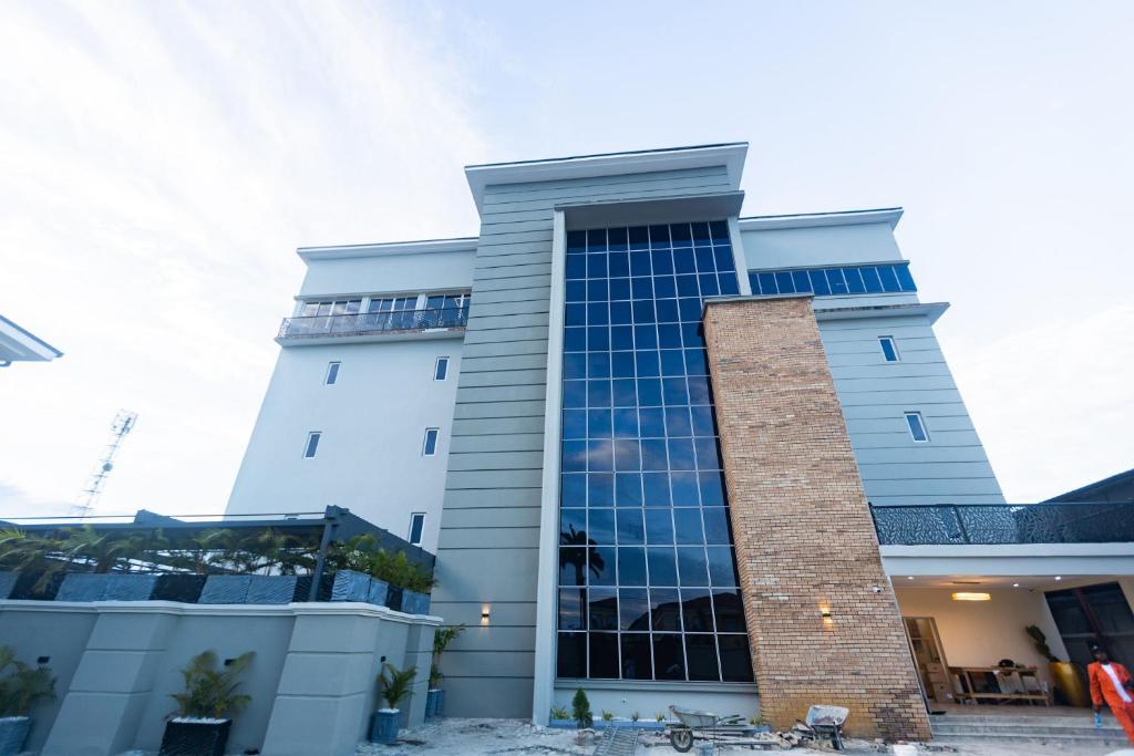 a tall white building with blue windows at Dodos Hotel Services in Port Harcourt