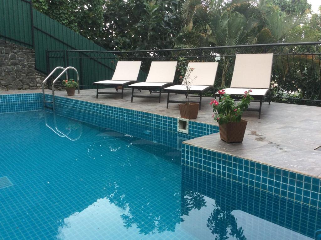 a swimming pool with lounge chairs and a blue tiled at HELFAROAN Spacious, Superb panoramic view! in Kandy