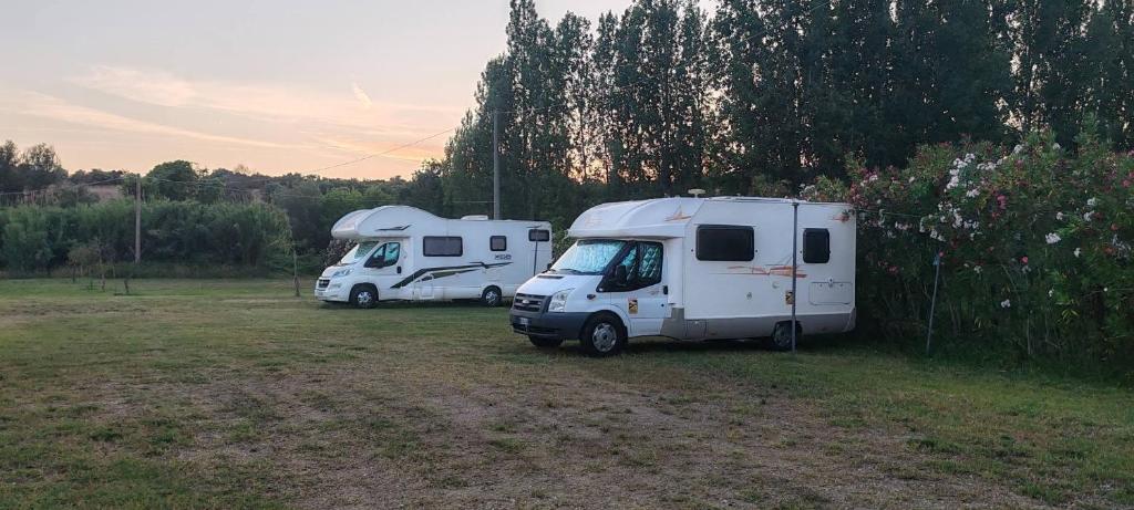 two rvs parked next to each other in a field at Villa Cilento Parking e Sosta Camper in Capaccio-Paestum