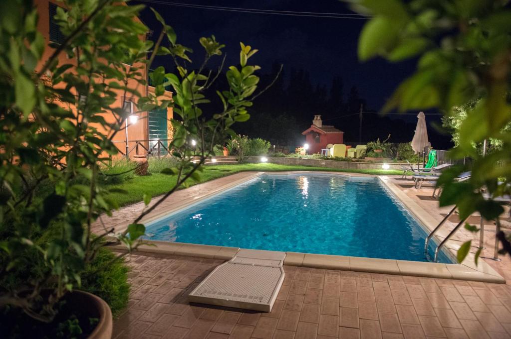 a swimming pool in a yard at night at Poggio Montali in Monte Roberto