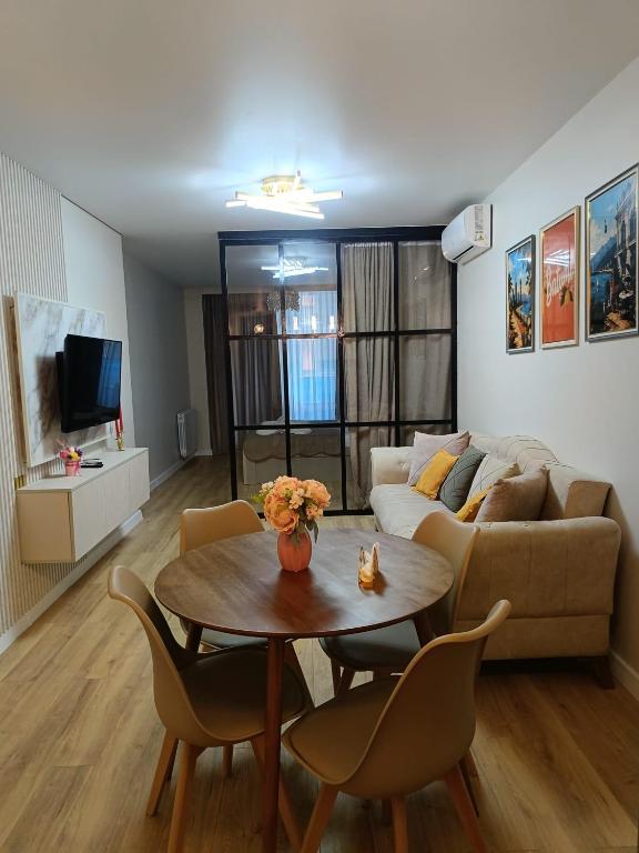 a living room with a table and a couch at Rainbow Residence Batumi in Batumi