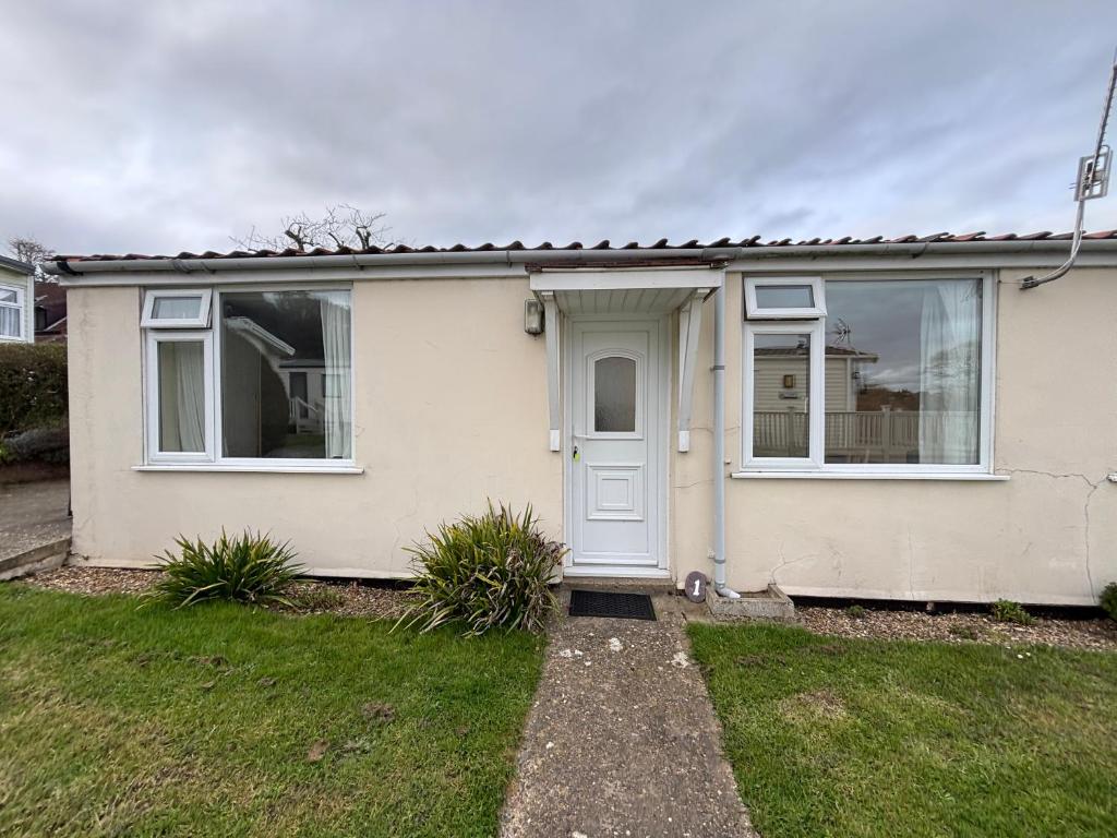 a white house with a white door and windows at 1 Bedroom Chalet in West Runton