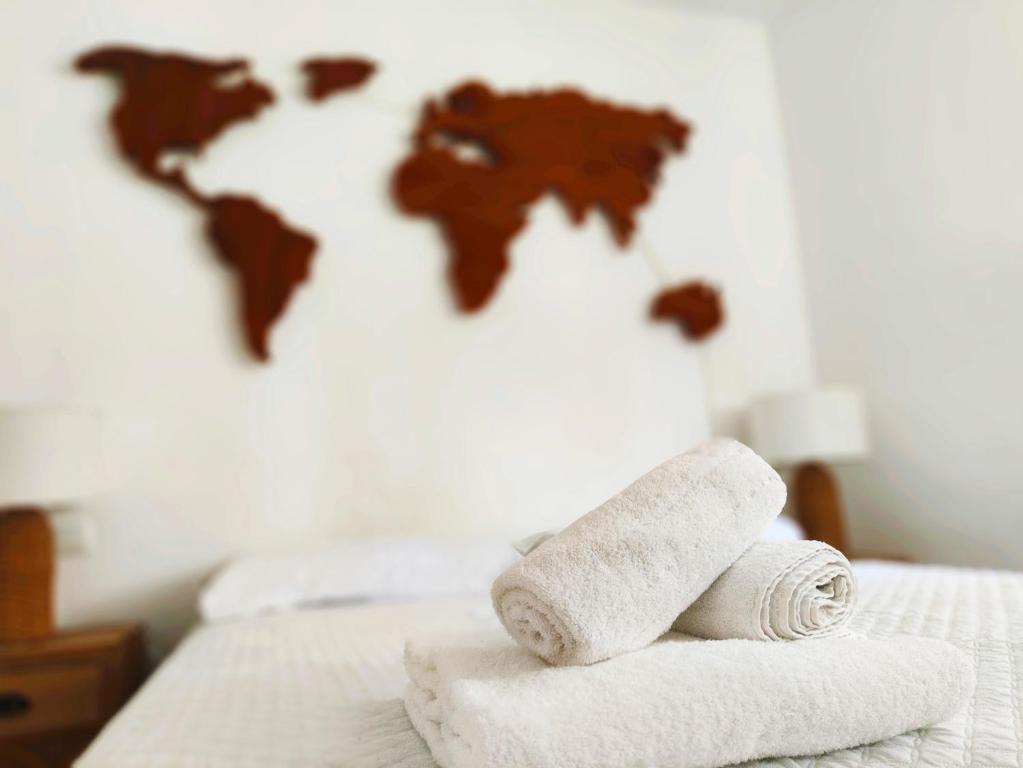 a roll of towels on a bed with a world map at Chill and Beach in Torremolinos