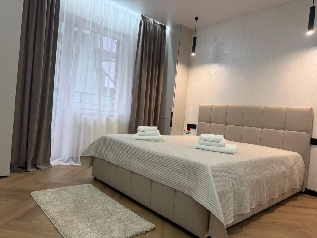 a bedroom with a large bed with towels on it at Поляна Апарт in Polyana