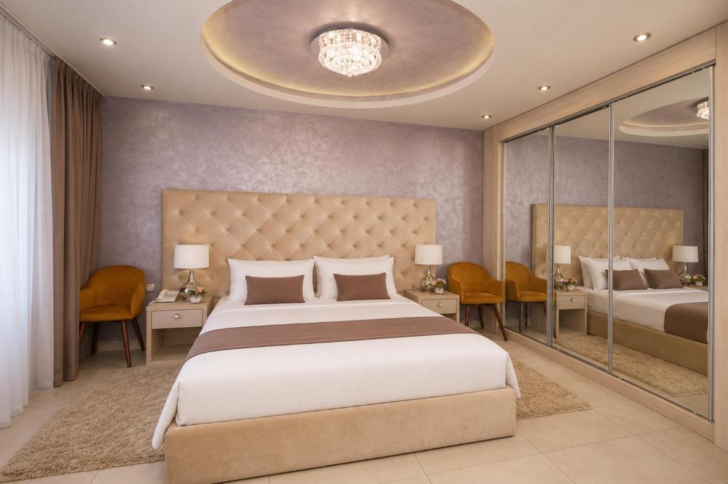 a bedroom with a king sized bed and a mirror at Hotel Bajadera Lux in Belgrade