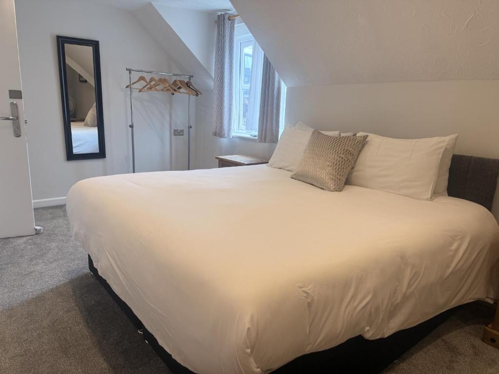 a bedroom with a large bed with white sheets and pillows at Star Studios in Southampton