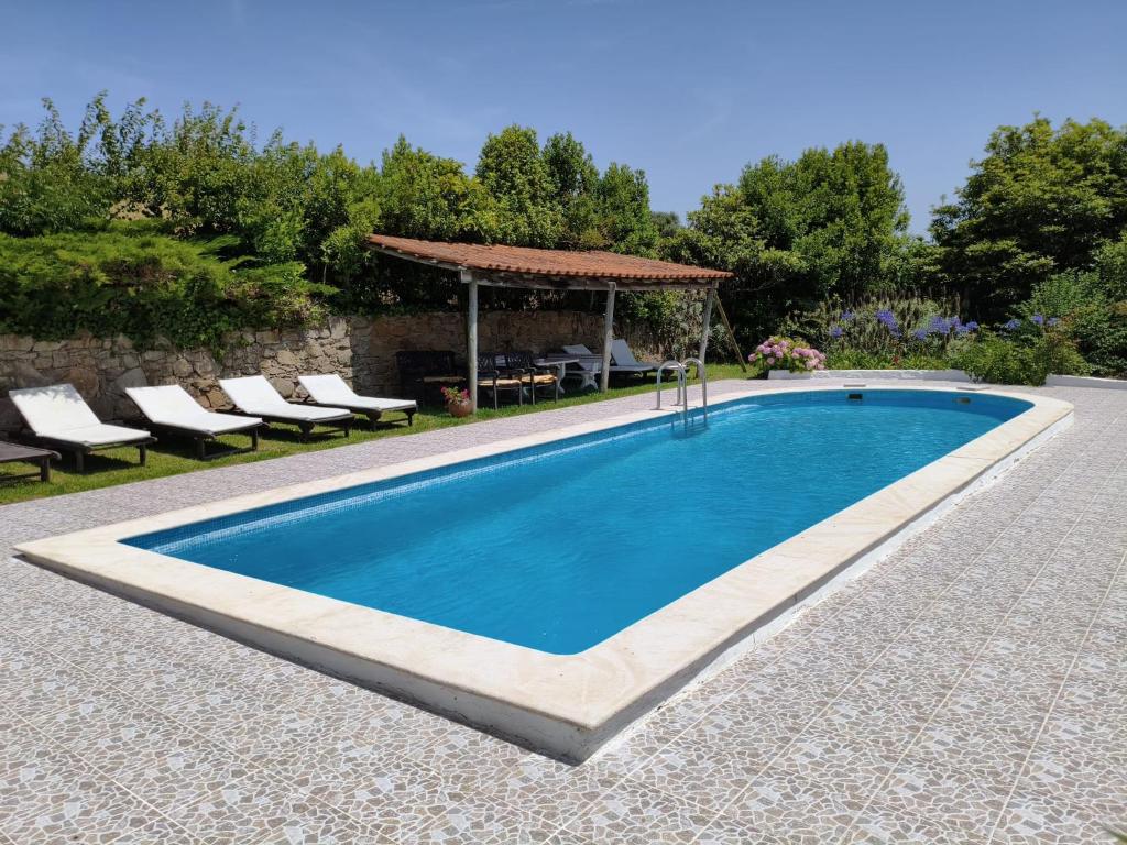 a swimming pool with a gazebo and chairs around it at Porto Monte in Maceira