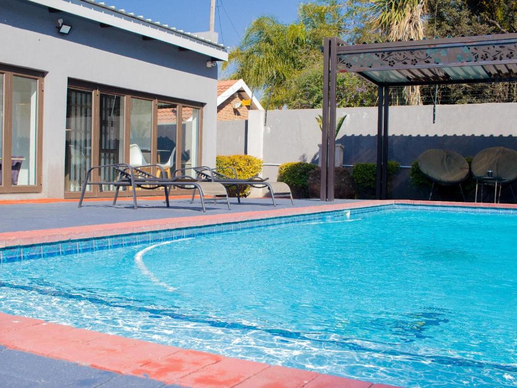 a swimming pool in front of a house at 5@Partridge Guesthouse in Newcastle