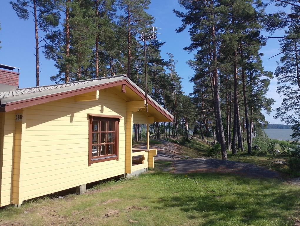 a small yellow cabin with a view of the water at Lomamökki Rantaniemi in Töfsala
