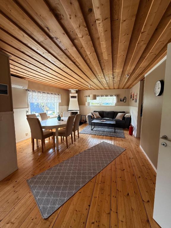 a living room with a wooden ceiling and a table at Camp Caroli Olala in Jukkasjärvi