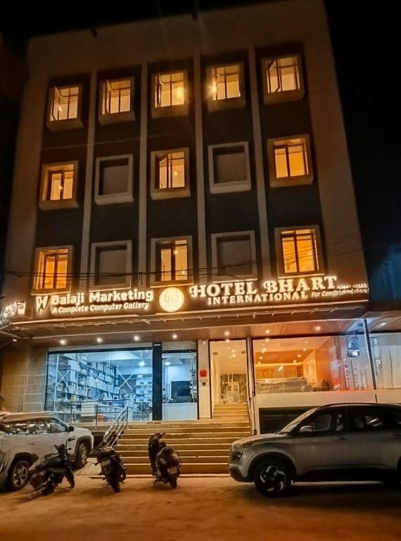 a building with cars parked in front of it at Hotel bharti international in Raipur