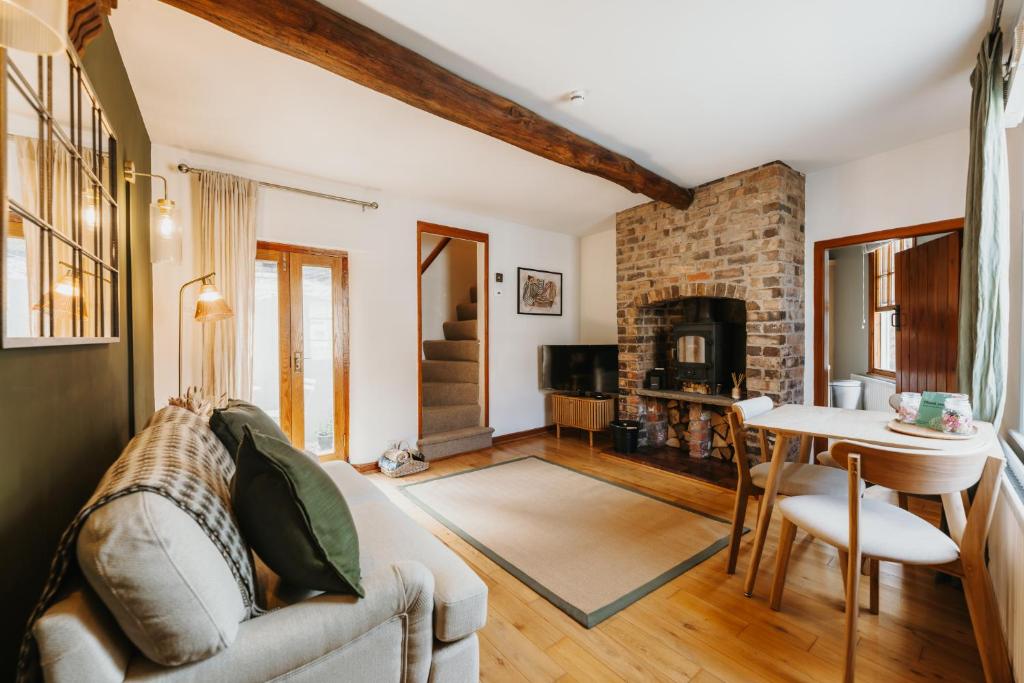 a living room with a couch and a table at Wenlock's Cosy Cottage in Much Wenlock