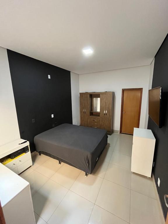 a bedroom with a bed and a black wall at CASA para TEMPORADA in Barra do Garças