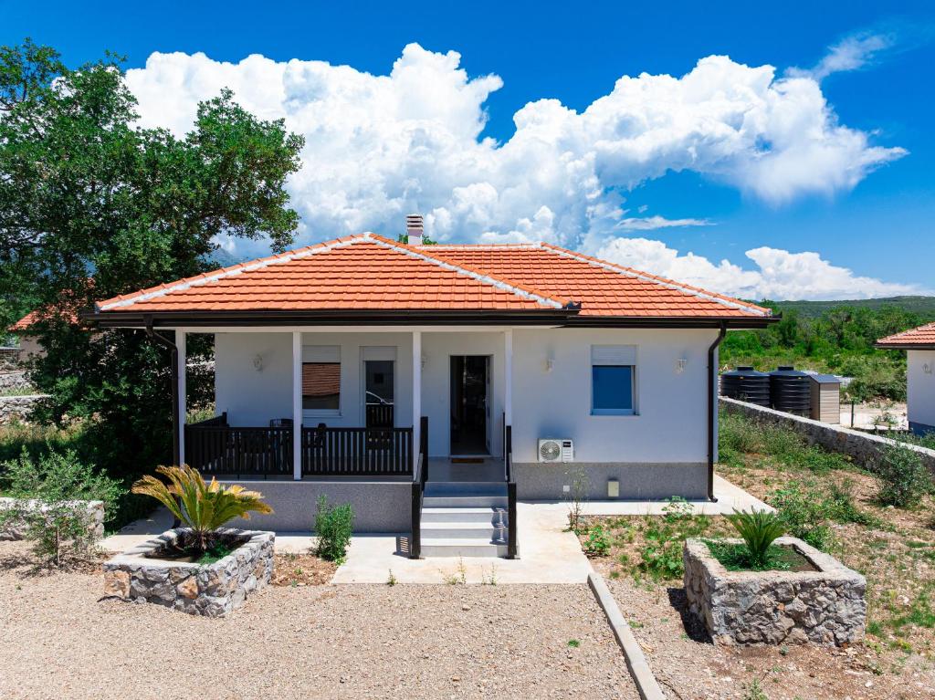 a small white house with an orange roof at Barcelona Hacienda in Gostovići