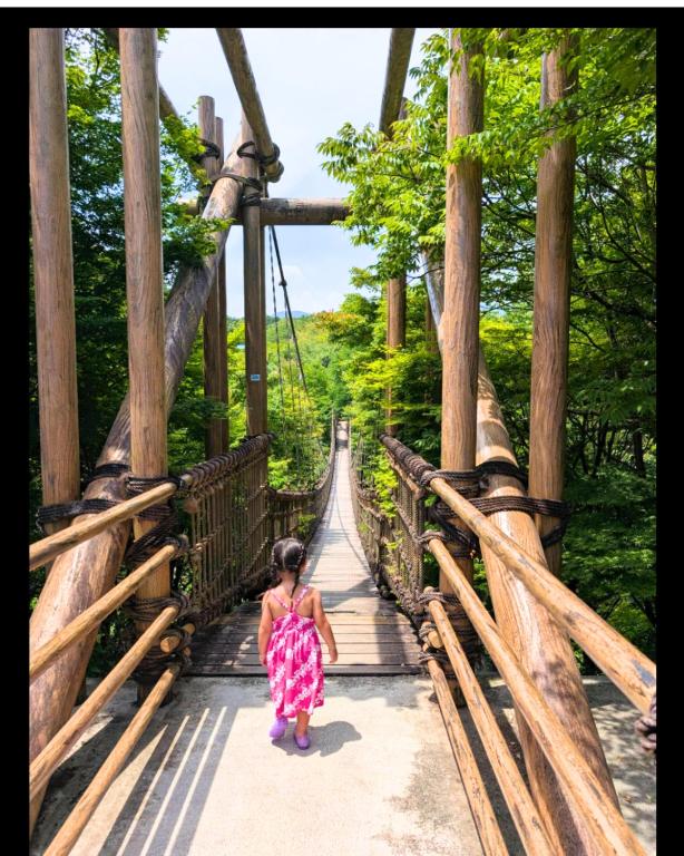 a little girl walking on a wooden bridge at Macchiato SHONAN - 綺麗な古民家一棟貸切-海まで5分-無料駐車場-自転車2台-独立乾燥機-お子様大歓迎 Private Traditional House Near Kamakura Hakone, Family-Friendly Stay in Hiratsuka