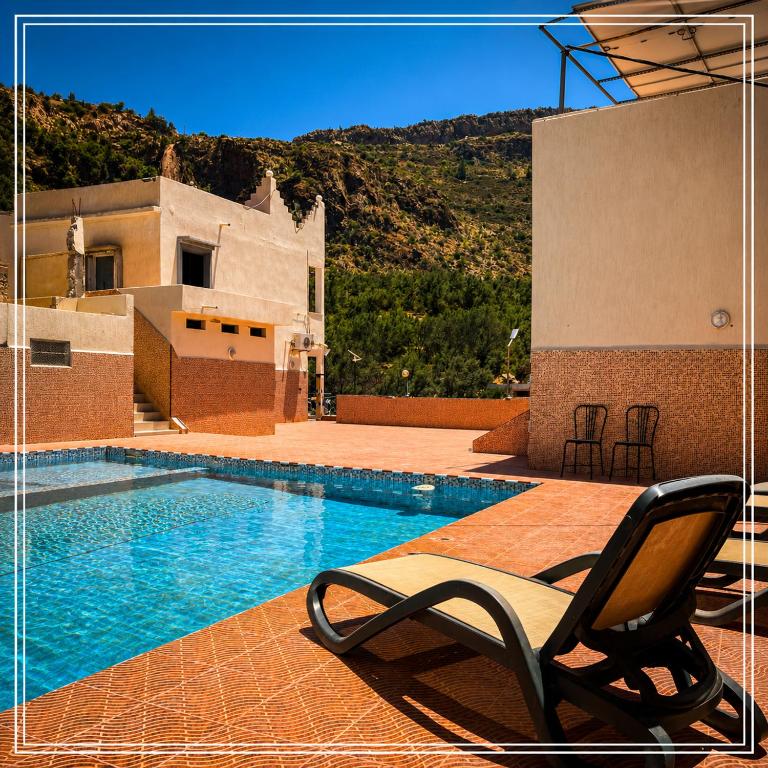 a chair sitting on a patio next to a swimming pool at Auberge Bab chellalat in Tamarout