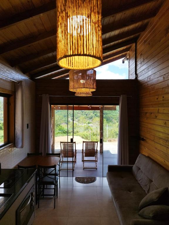 a living room with a couch and a chandelier at Cabana Mais Natureza in Santo Amaro da Imperatriz