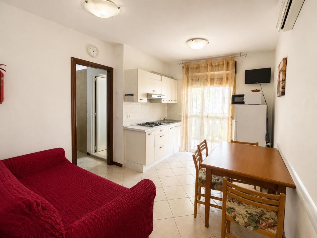 a living room with a red couch and a table at Anthea - Timavo apartament 1 in Lignano Sabbiadoro