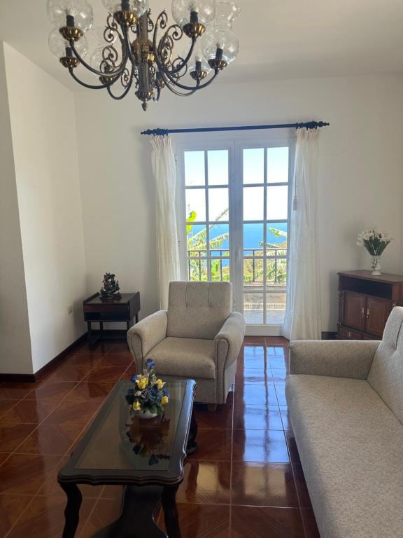 a living room with a chandelier and a couch and a table at Casa 52 in Machico