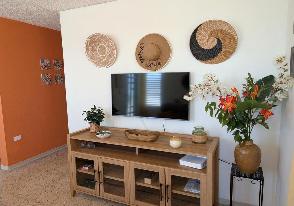 a living room with a television and hats on the wall at Sun Seekers Retreat 3 bedrooms in Santa Maria