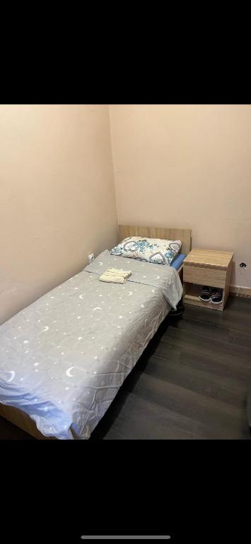 a small bedroom with a bed and a night stand at jack hostel with private bathroom in Sremski Karlovci