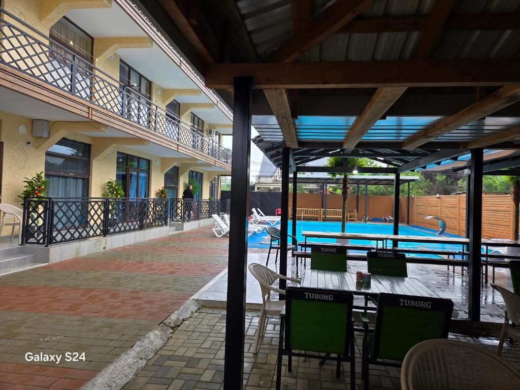 a swimming pool with tables and chairs next to a building at Hotel Datuna Aurum in Kobuleti