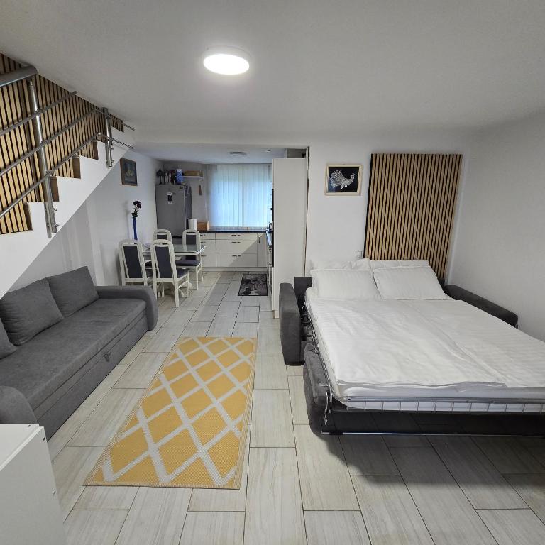 a bedroom with a bed and a couch and a kitchen at Pri tetki 2 in Kranj