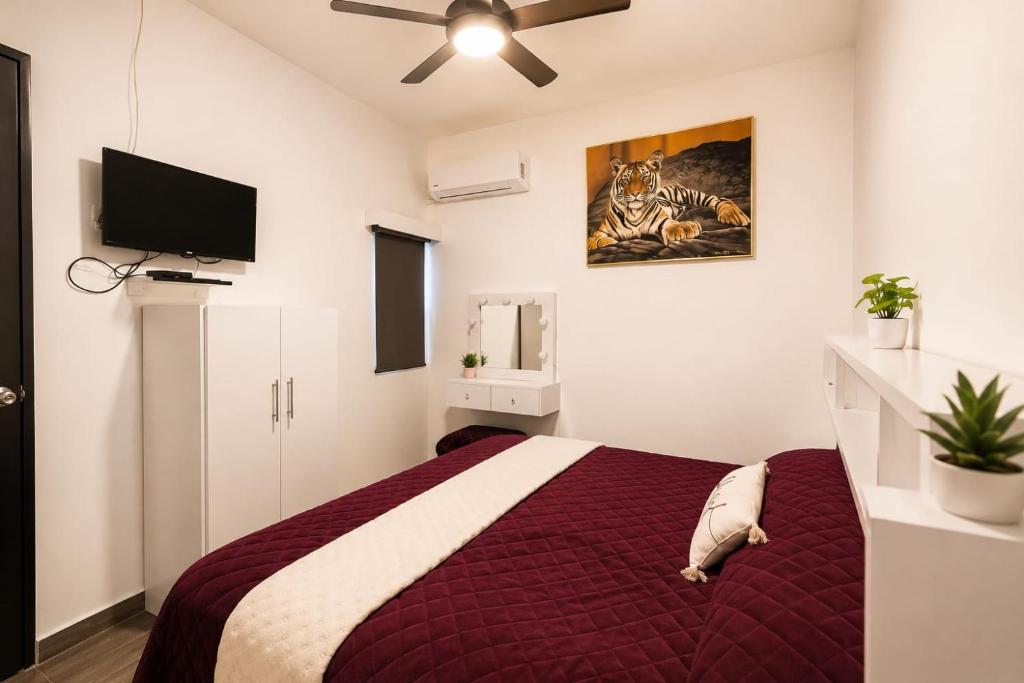 a bedroom with a bed and a flat screen tv at Alameda Suites & CAS - Centro Monterrey in Monterrey