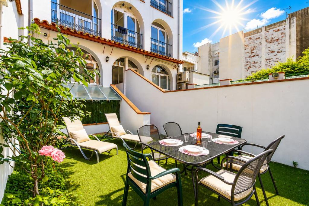 a patio with a table and chairs and the sun at Mestral 1 1 Roses - Immo Barneda in Roses