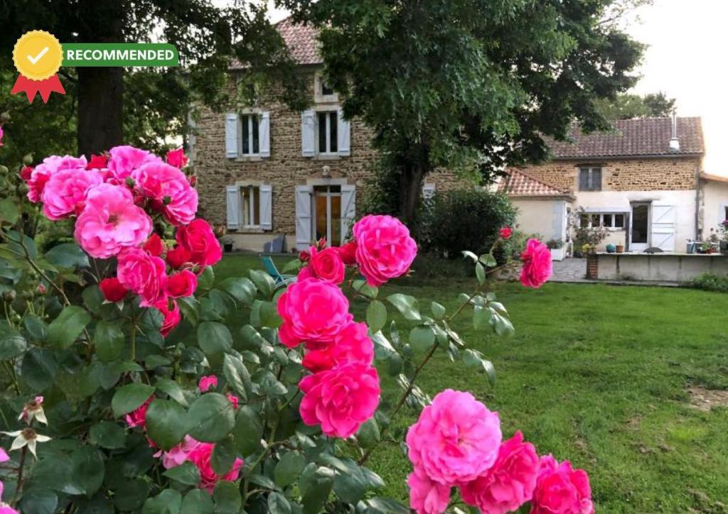 a group of pink roses in front of a house at Maison Piffou in Malaussanne