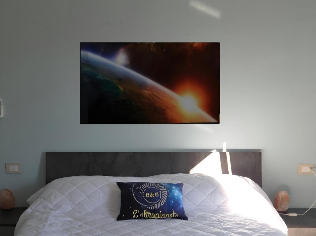 a painting hanging above a bed in a bedroom at B & B L'Altropianeta in Spoltore