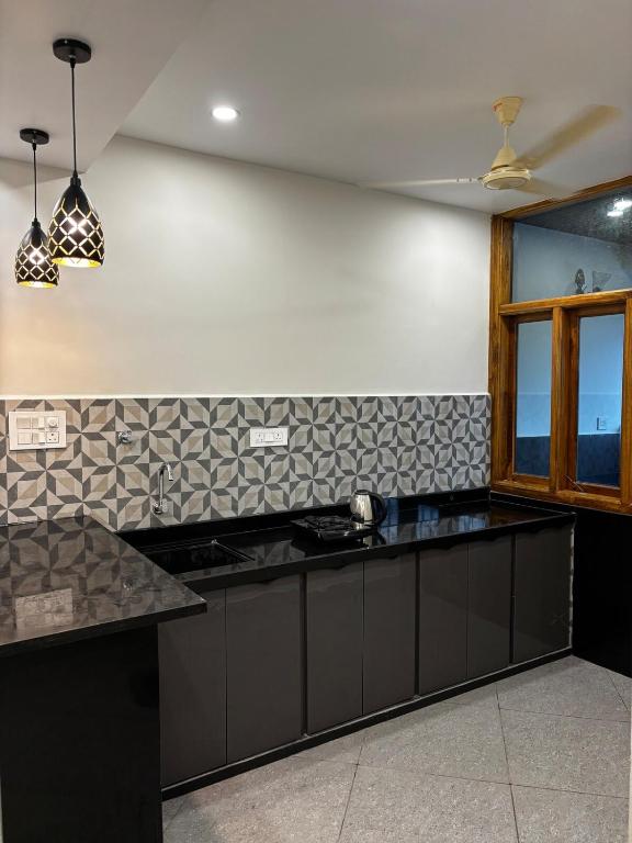 a kitchen with a black counter top and a window at 1Rk Karwar downtown Studio in Kārwār