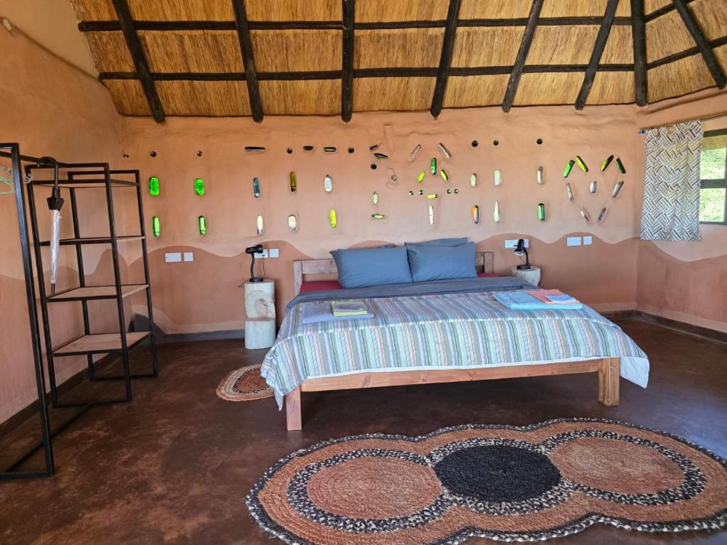 a bedroom with a bed in a room with a wall at Marudzi Sunset Lodge in Umtali