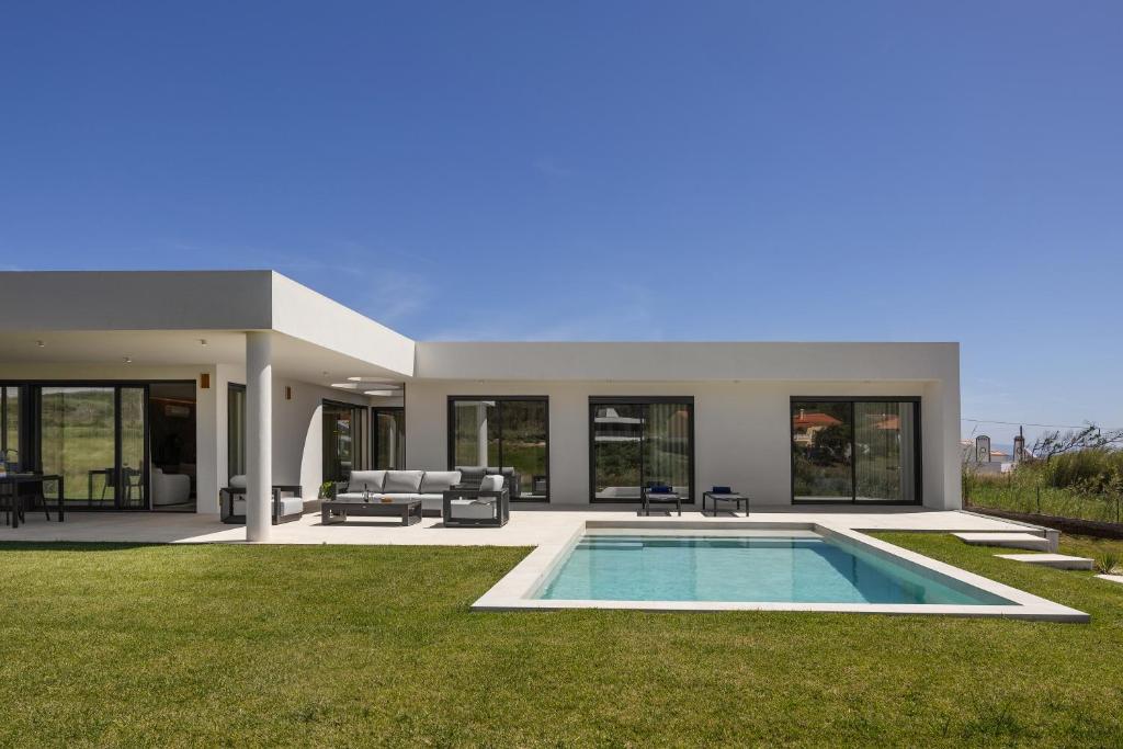 a modern house with a swimming pool in the yard at Quinta da Lagoeira in Caldas da Rainha