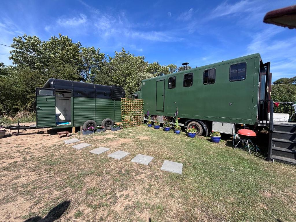 a green trailer parked next to a green trailer at The Carriage Lorry at Tilleys Glamping in Birchington