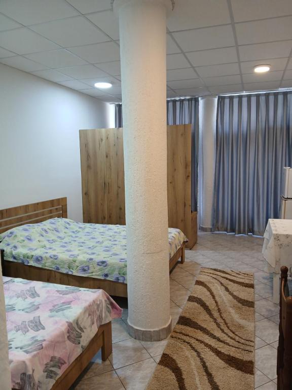 a room with two beds and a pillar in it at Eni Rooms 2 in Ohrid