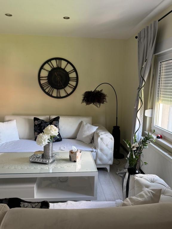 a living room with a couch and a clock on the wall at Villa Magnifica in Mostar