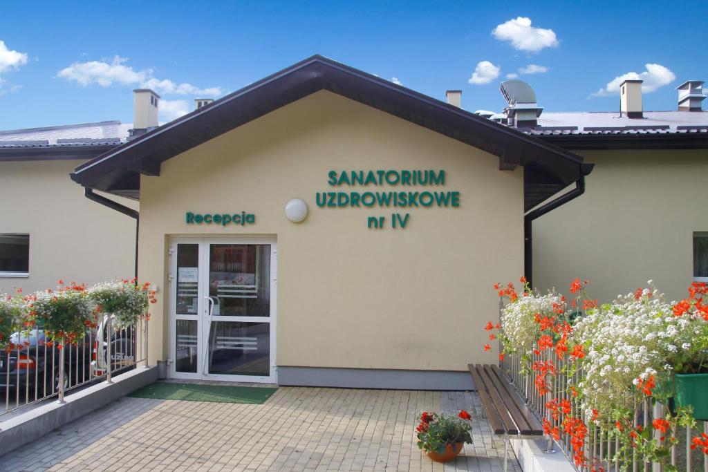 a white building with a sign on the side of it at Sanatorium Uzdrowiskowe nr IV in Iwonicz-Zdrój